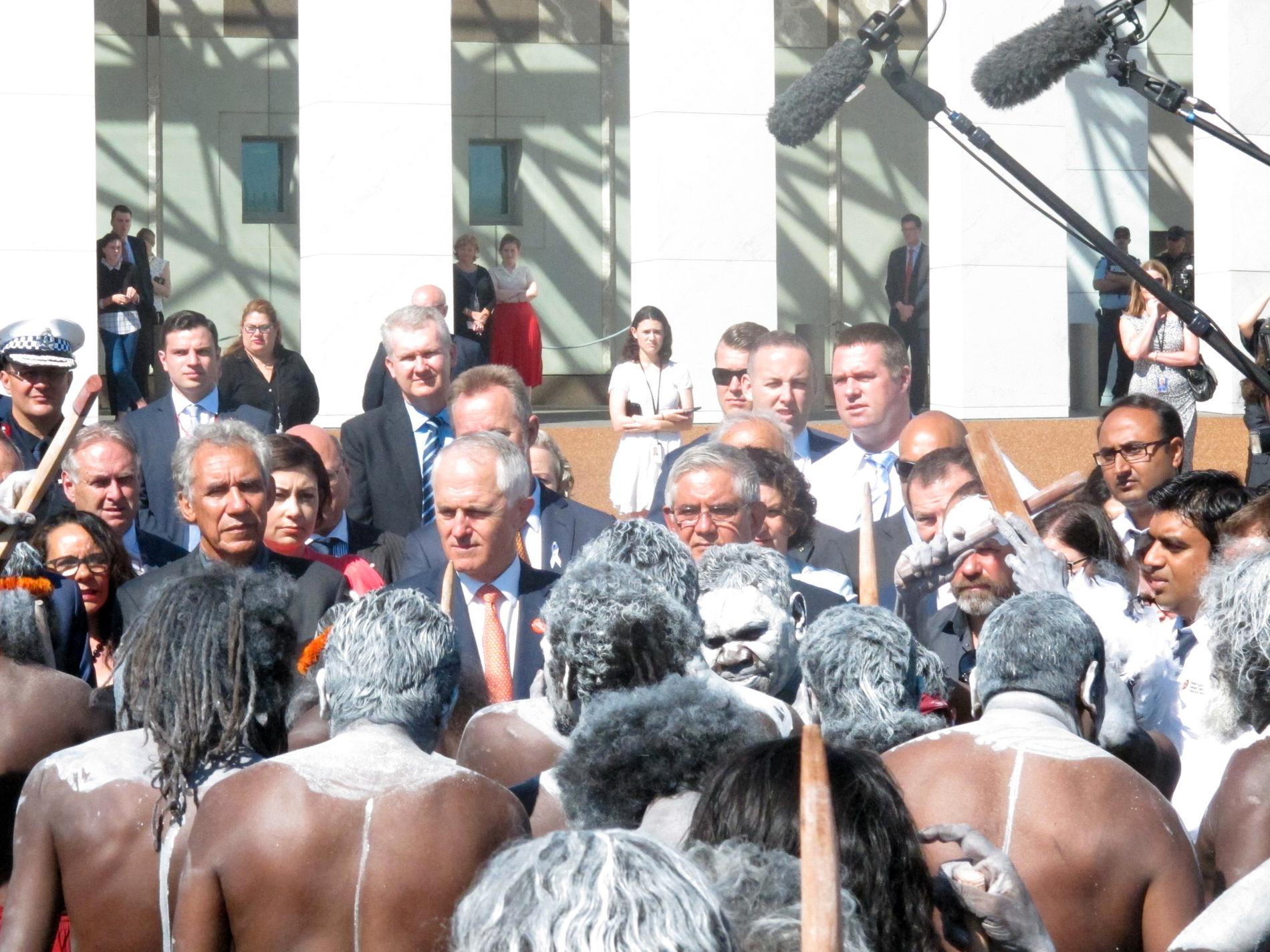 Australiens premiärminister Malcolm Turnbull, i orange slips i mitten, tar emot en aboriginsk dansgrupp inför en ceremoni utanför parlamentet i Canberra i november 2016. Arkivbild.