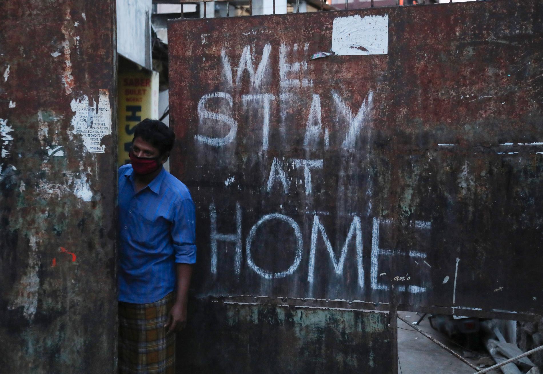 "Vi stannar hemma" har sprejats på en port i Hyderabad. Men Indien gör sig redo att slopa ännu fler virusrelaterade restriktioner. Bild från april.