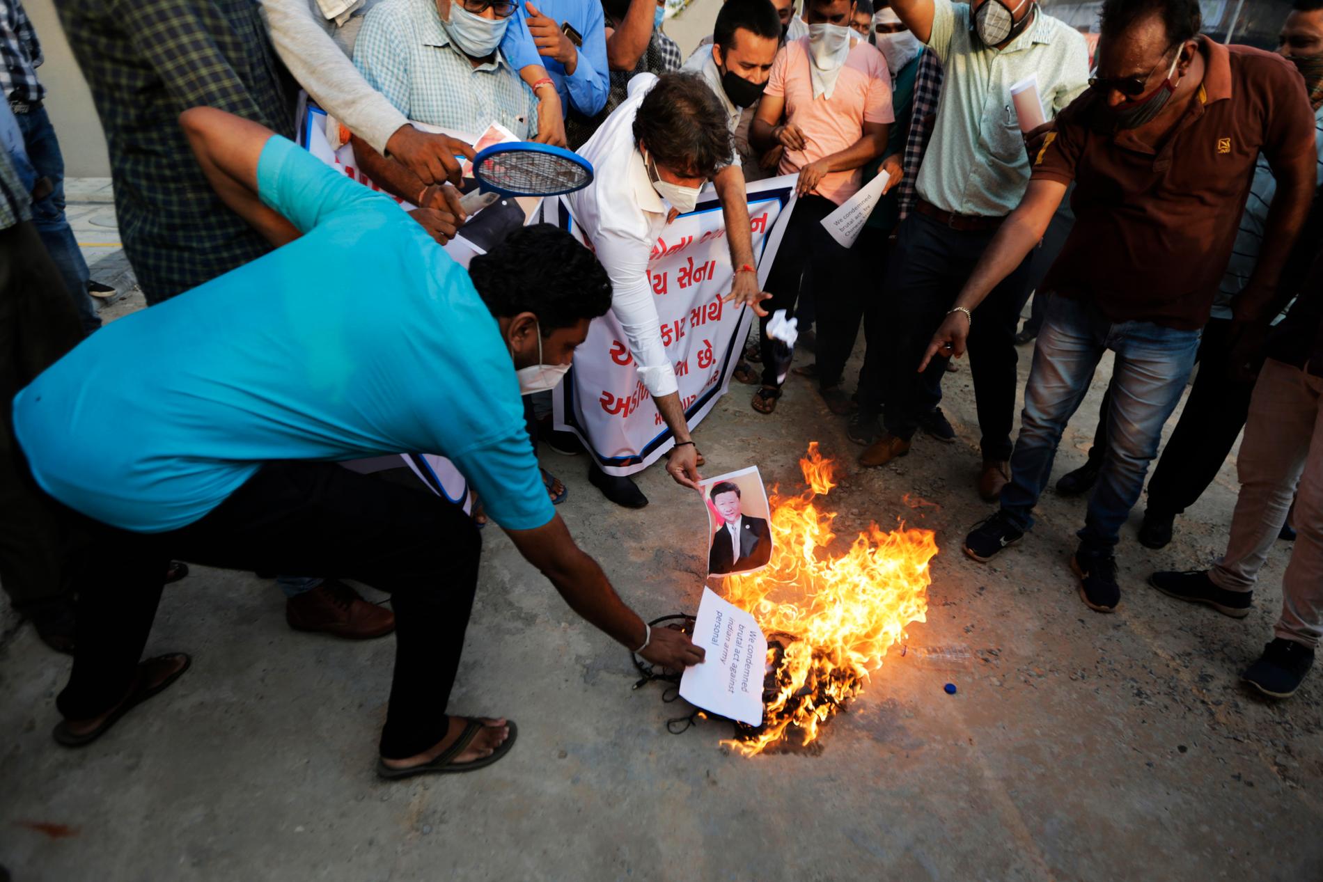 Den kinesiske presidenten Xi Jinpings porträtt bränns under en protest i indiska Ahmedabad sedan tre indiska soldater dödats vid en omdiskuterad gränsövergång.