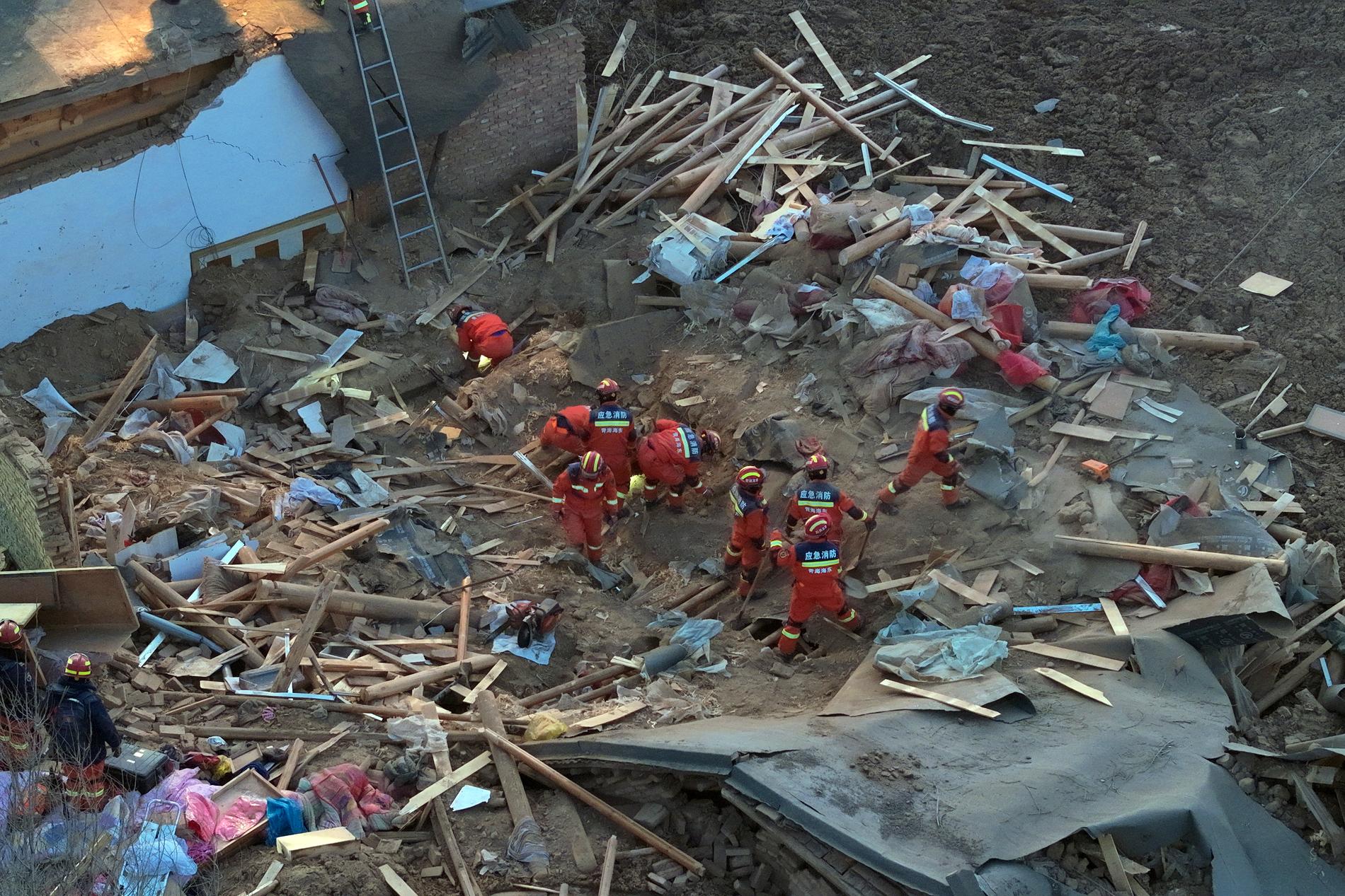 Räddningsarbetare letar bland rasmassor i en del av staden Haidong.