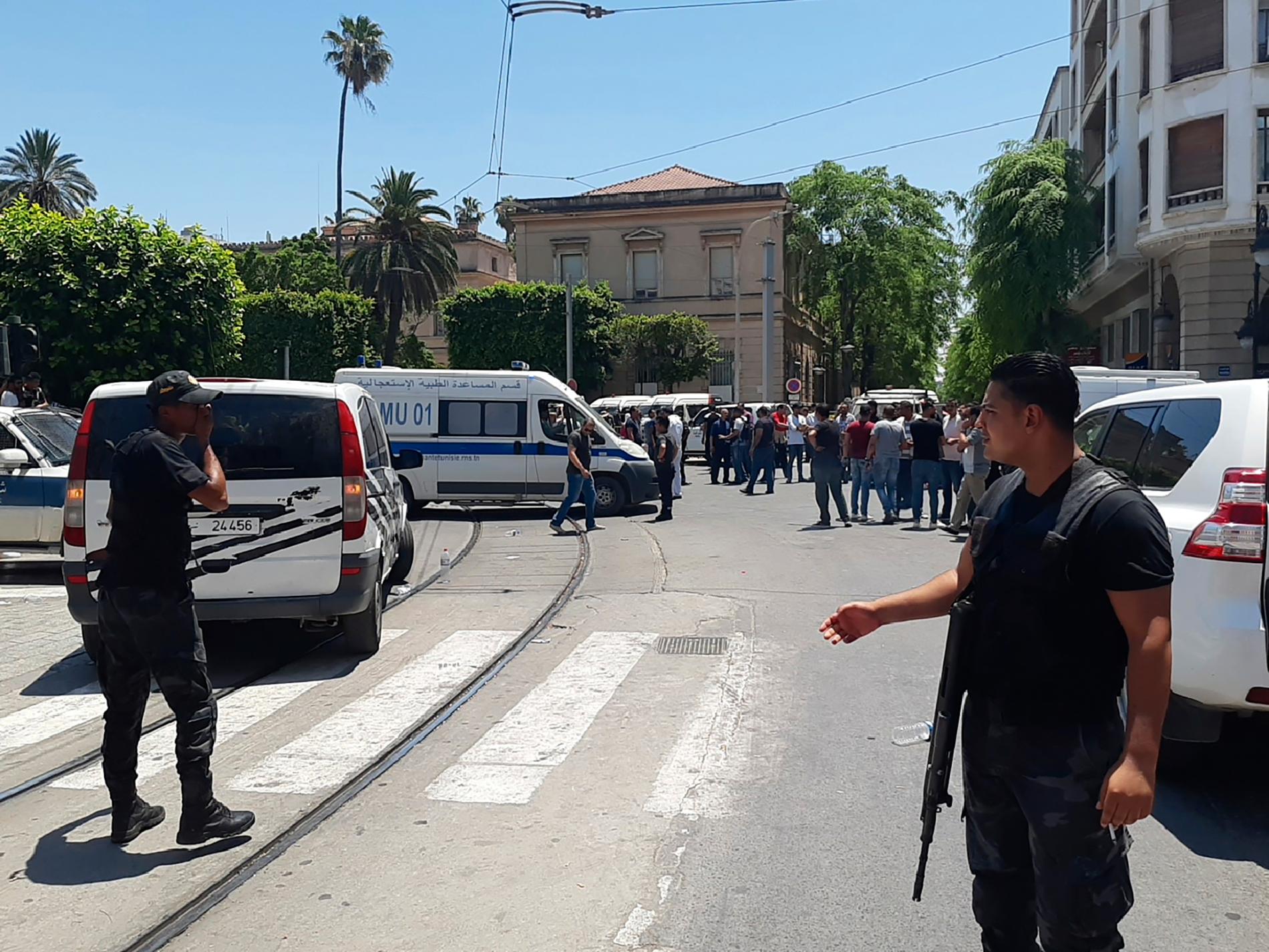Tunisisk polis vaktar avspärrningarna runt attentatsplatsen.