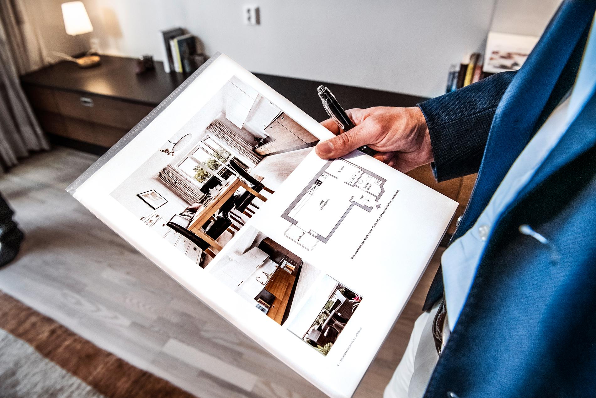 En mäklare visar upp ett informationsblad om en bostadsrätt till salu. Arkivbild.