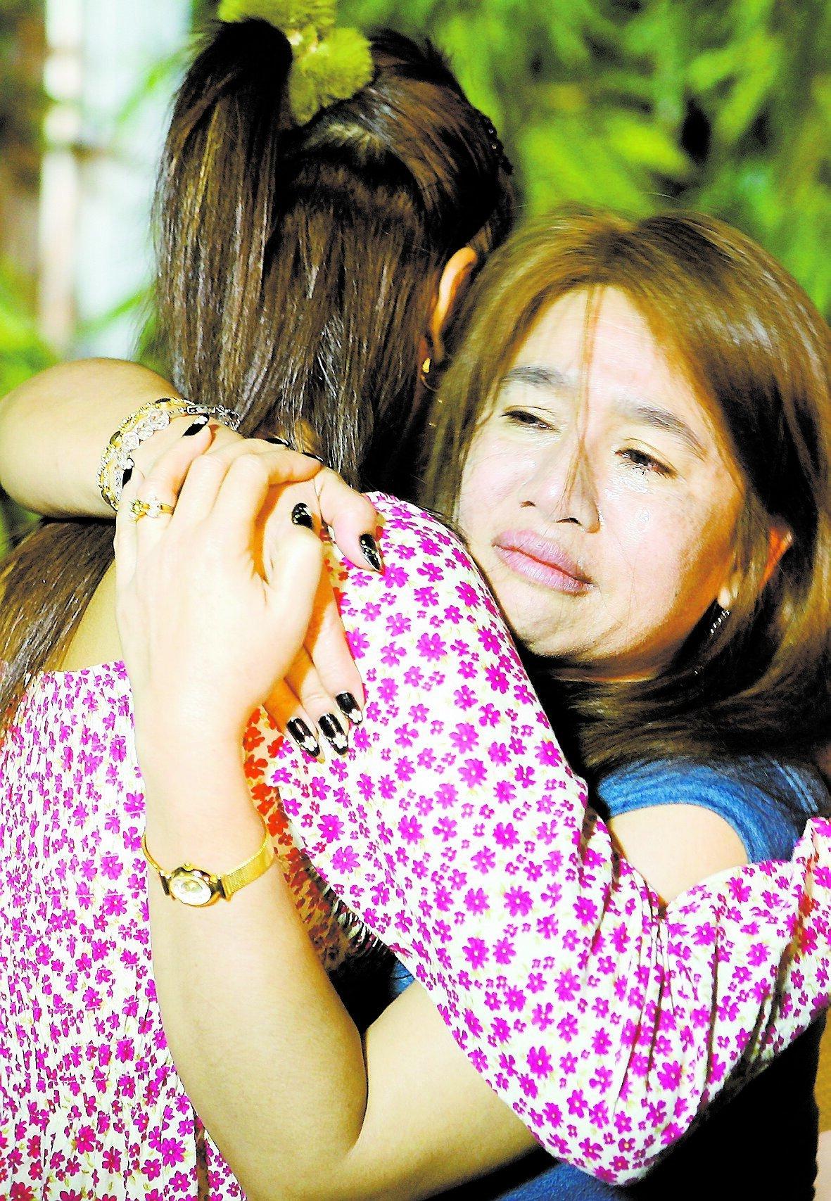 Två kvinnor tröstar varandra utanför det eldhärjade diskoteket. Bland gästerna – och dödsoffren – fanns både thailändare och turister.