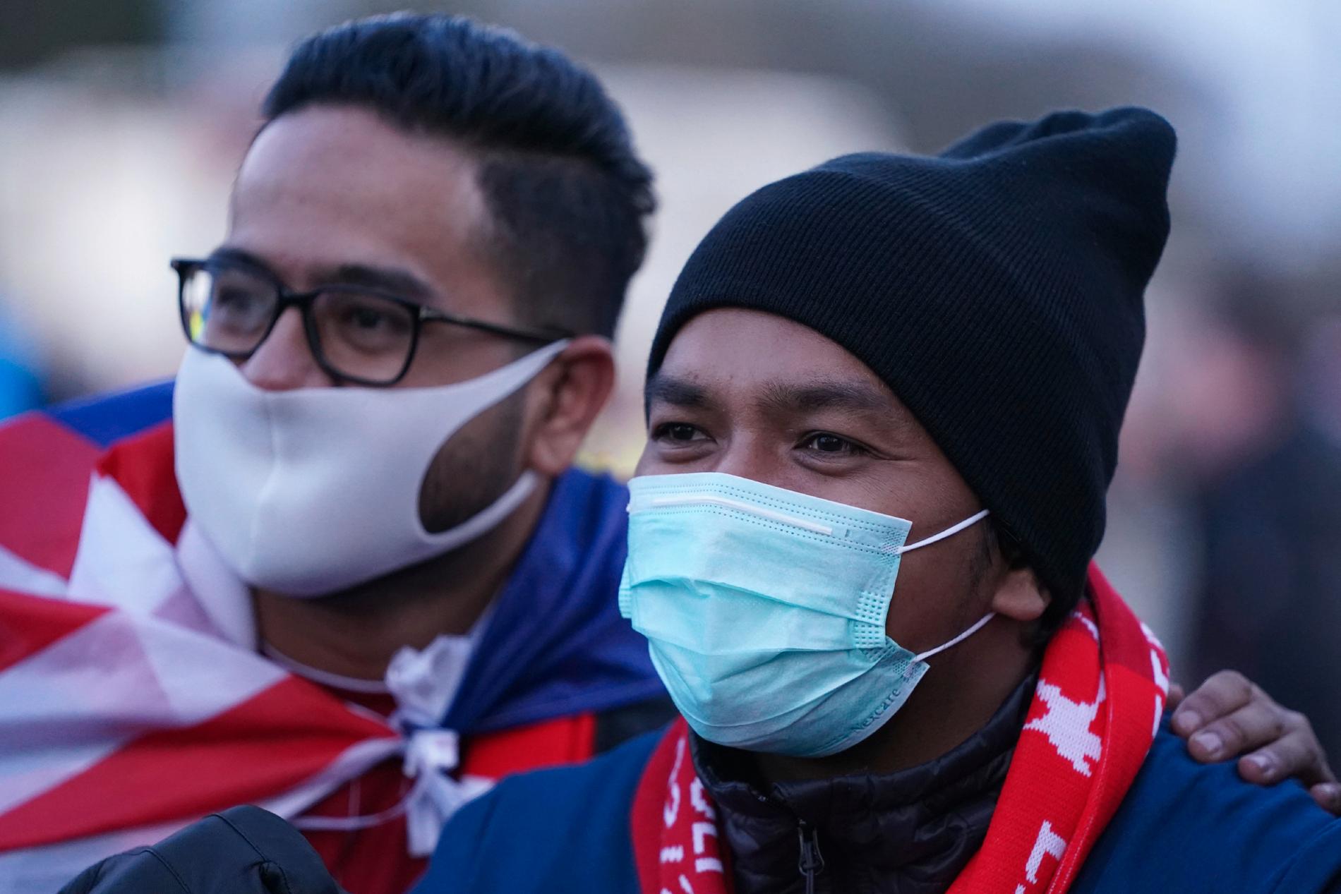 Fans med munskydd utanför Anfield i våras.