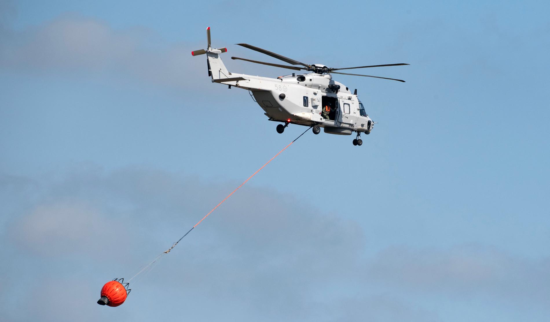 En helikopter 14 vattenbombar under en uppvisning på flygflottiljen F17 i Kallinge i augusti.