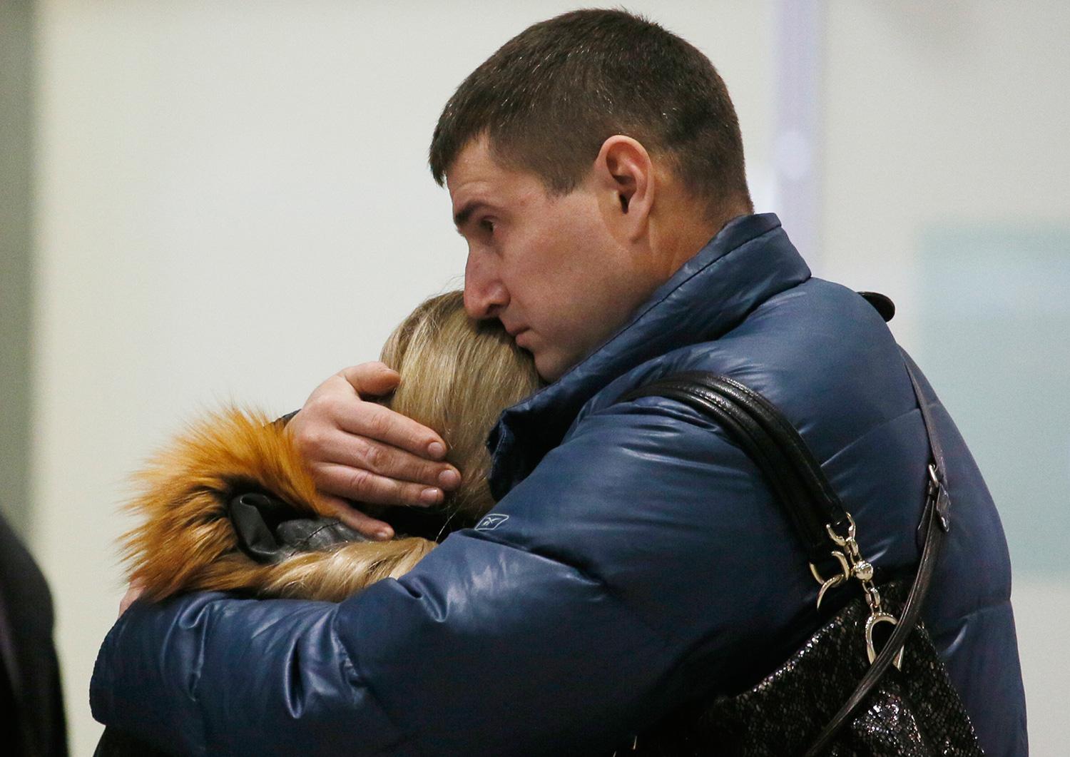 En man kramar om en kvinna på flygplatsen i Sankt Petersburg.