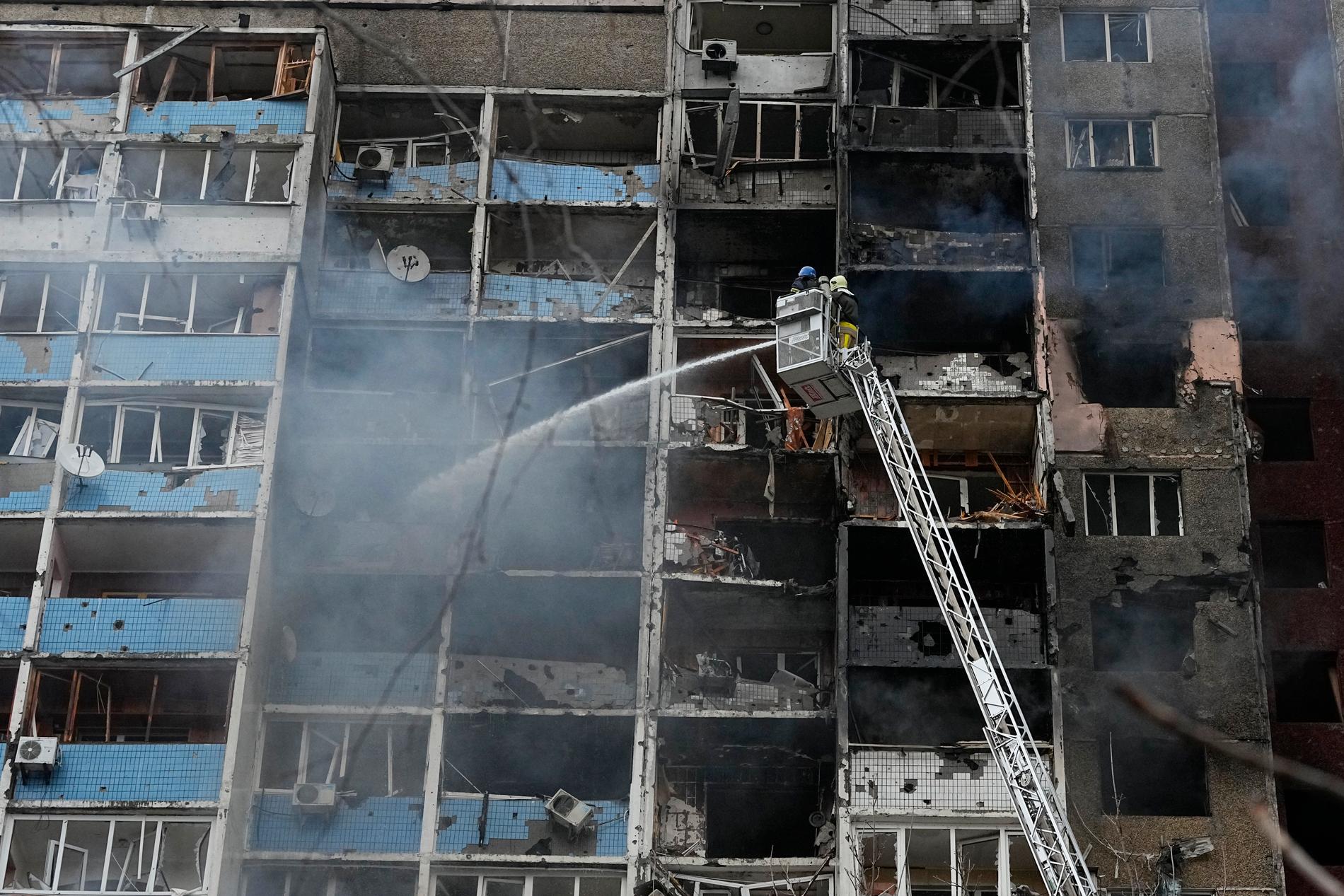 Brandmän arbetar med att släcka bränder efter att en raket träffat ett bostadshus i Kiev under natten mot onsdagen.
