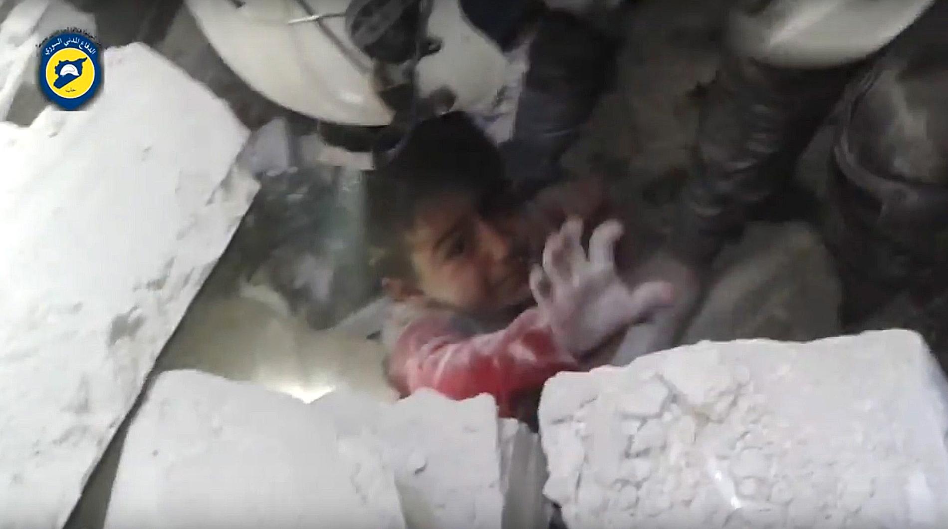 Ett barn grävs ut ur rasmassorna efter en av de senaste dagarnas bombningar i Aleppo. Bilden har gjorts tillgänglig av den syriska hjälporganisationen "White Helmets".