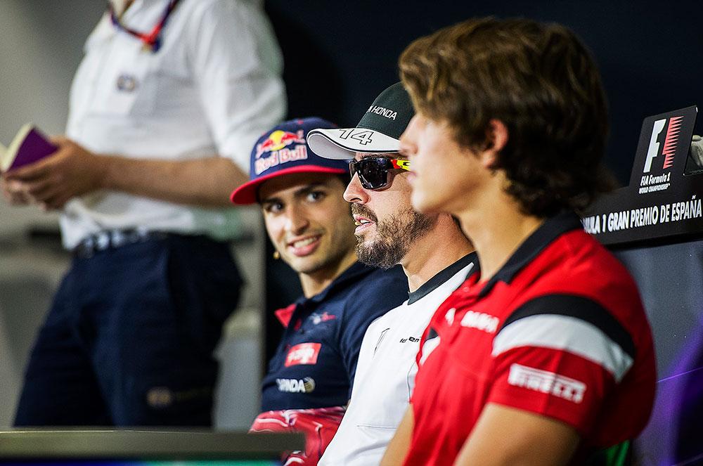 Carlos Sainz (t.v.) lyssnar på Fernando Alonso under en välbesökt presskonferens.