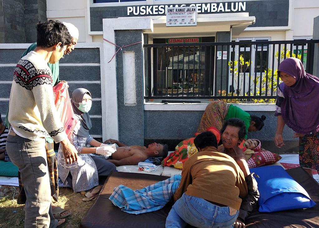 Sjukvårdspersonal behandlar en skadad person utanför ett sjukhus i byn Sembalun Selong.