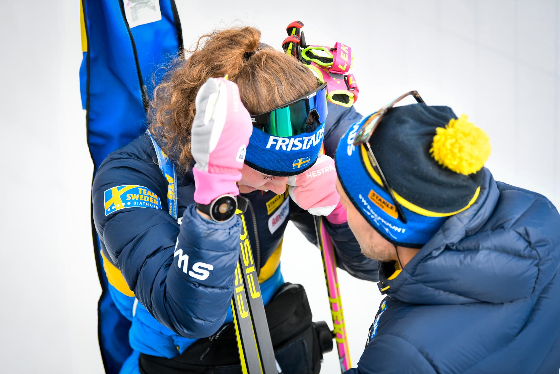 Hanna Öberg tröstas av tränaren Johannes Lukas efter att ha skjutit bort sig i sprinten.