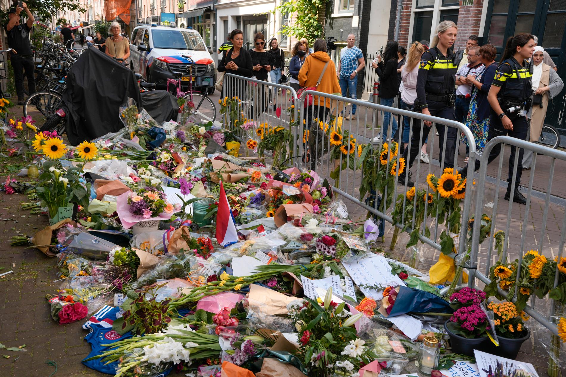 Poliser och blommor på den plats där den nederländske journalisten Peter R de Vries sköts ihjäl i juli. Arkivbild.