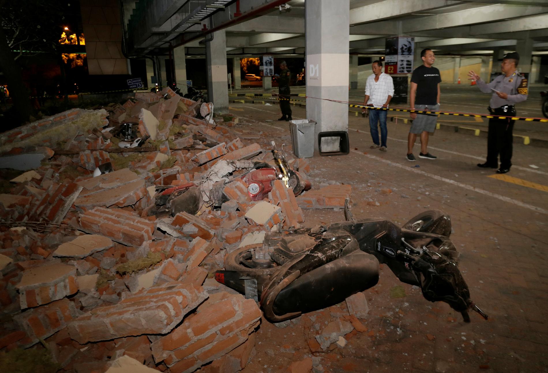 Polis undersöker rasmassor efter jordbävningen på närbelägna ön Lombok, här vid ett köpcenter i Kuta på Bali. 