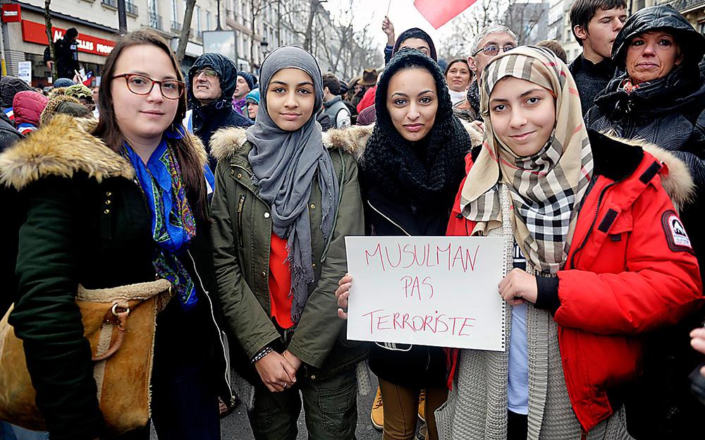 Över en miljon människor samlades i helgen för att hedra offren i terrorattacken mot satirtidningen Charlie Hebdo. Amen Belmecheri, längst till höger, tillsammans med sina väninnor.  Skylten betyder ” Vi är muslimer, inte terrorister”.