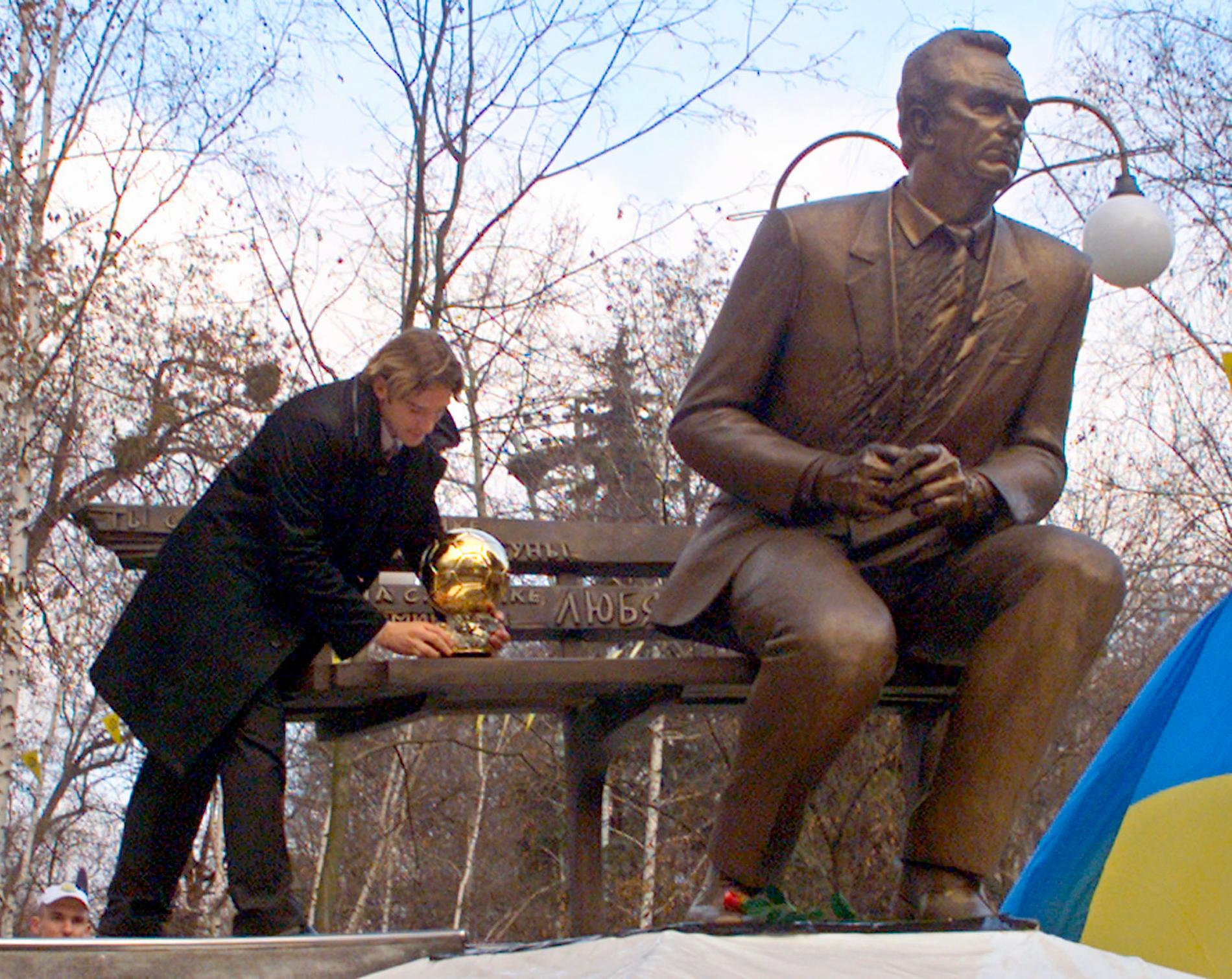 Andrij Sjevtjenko placerar Ballon d'Or-trofén vid statyn av Valerij Lobanovskij.