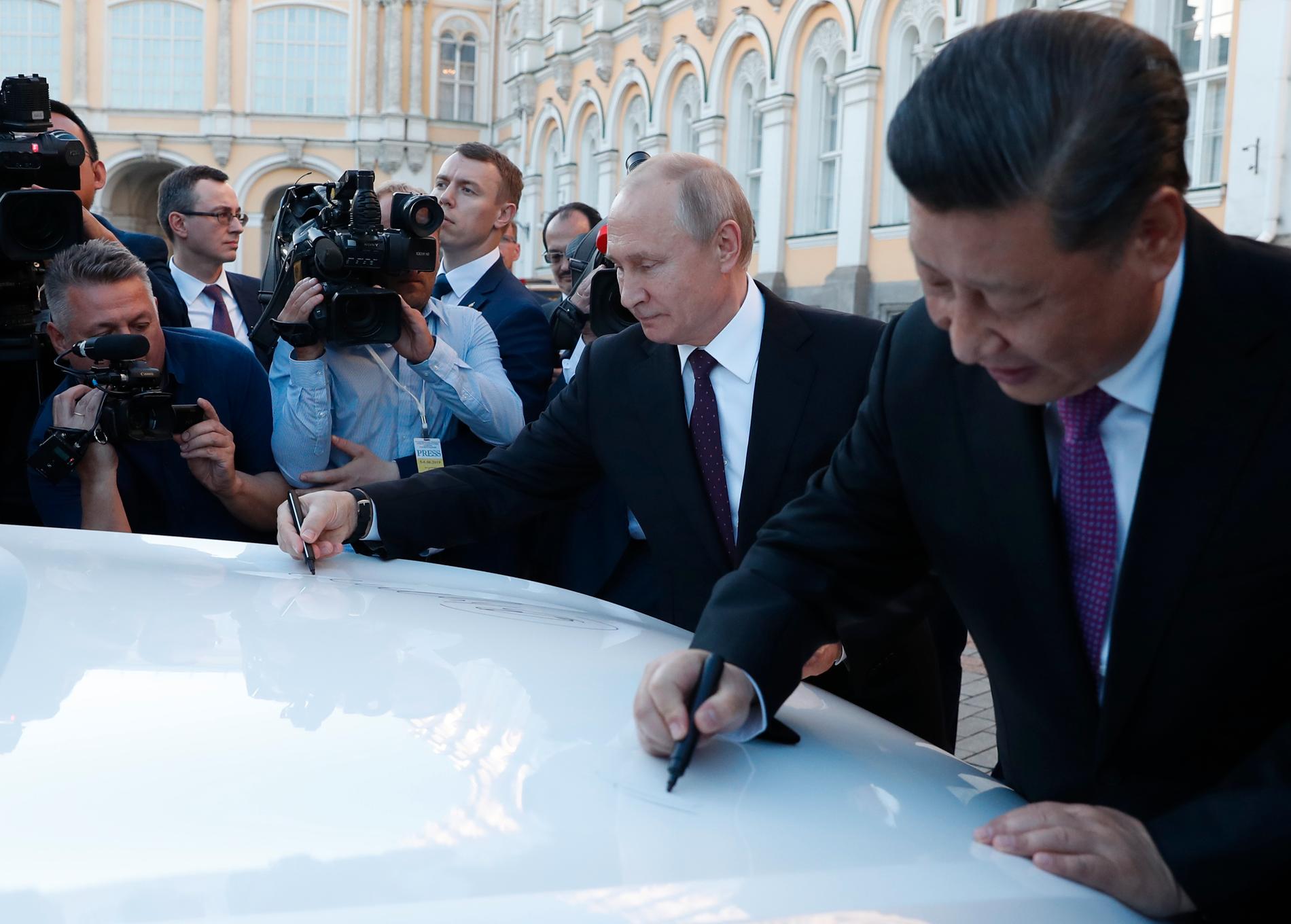 Vladimir Putin och Xi Jinping signerar motorhuven på en rysktillverkad Haval F7 suv i juni 2019.