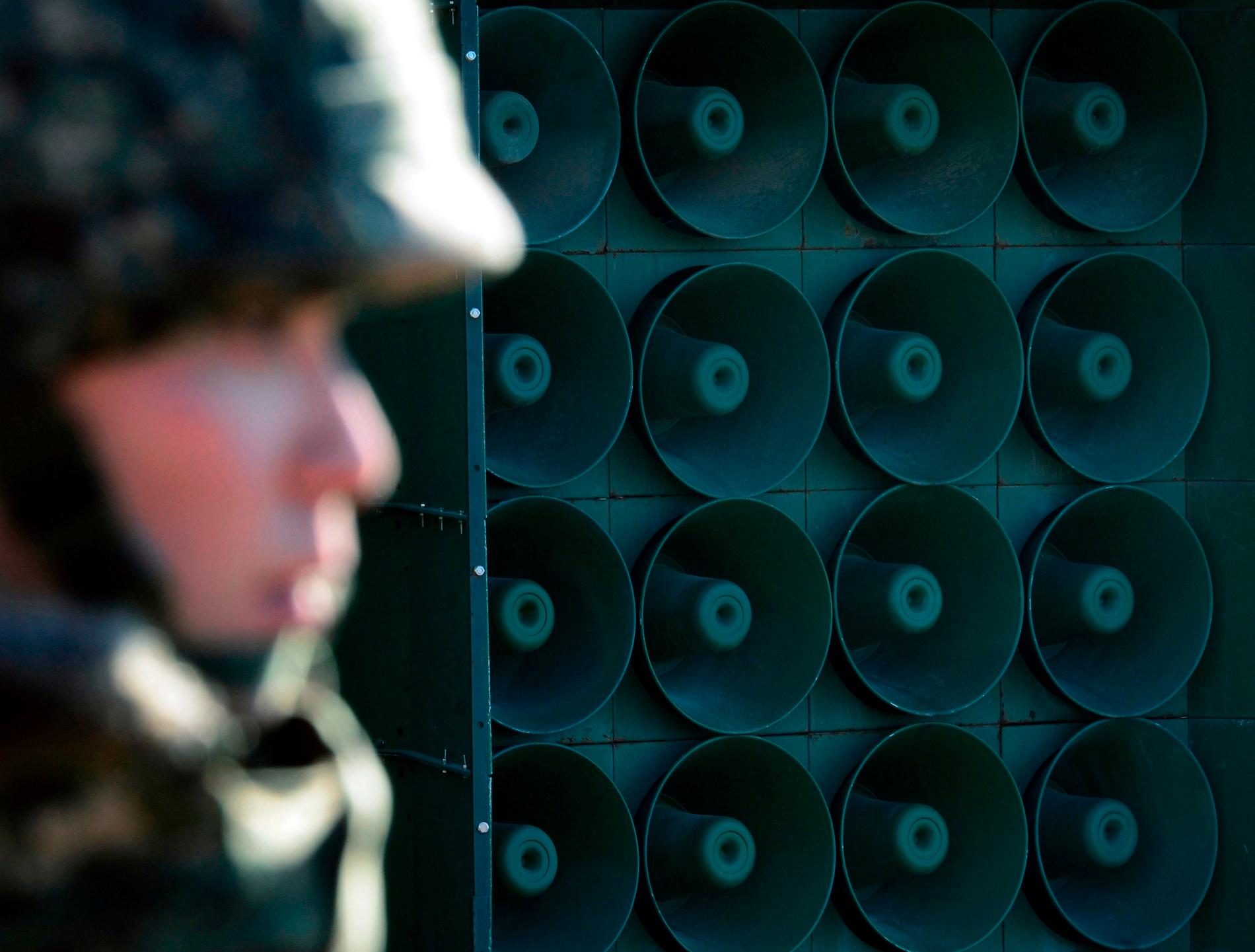 En sydkoreansk soldat framför en högtalarvägg vid gränsen. Bilden är från 2016.