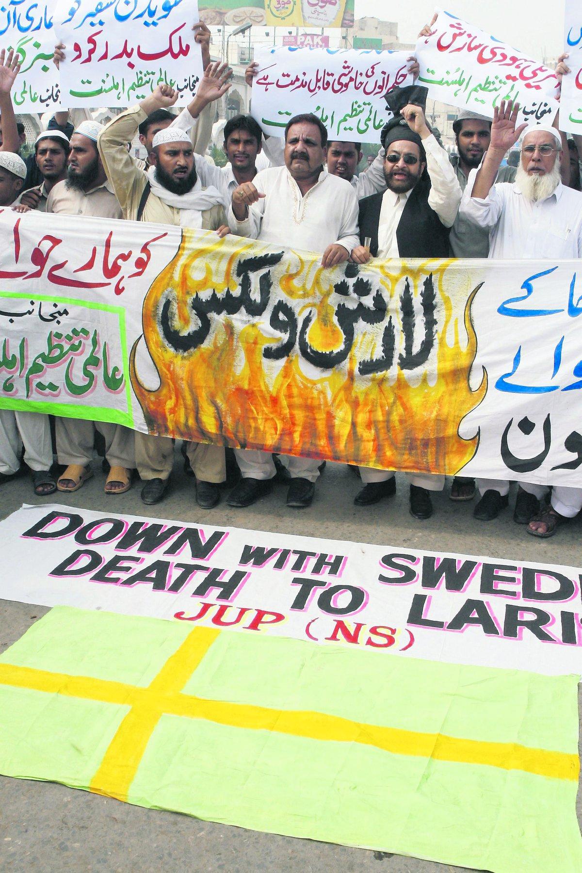 PROTESTERAR MOT SVERIGE Vid en protest i Pakistan hösten 2007 håller demonstranterna upp en svensk flagga med Lars Vilks namn och fördömer hans karikatyr av Muhammed.