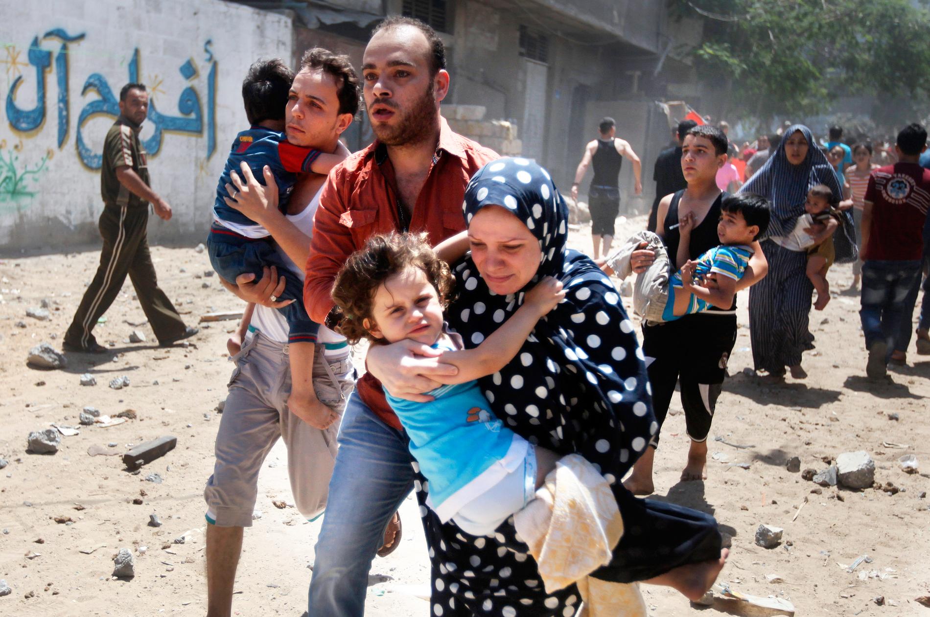 Palestinier flyr undan en attack i Gaza city. Enligt palestinska myndigheter dödades minst 23 personer på Gaza-remsan den 9 juli. Foto: Reuters