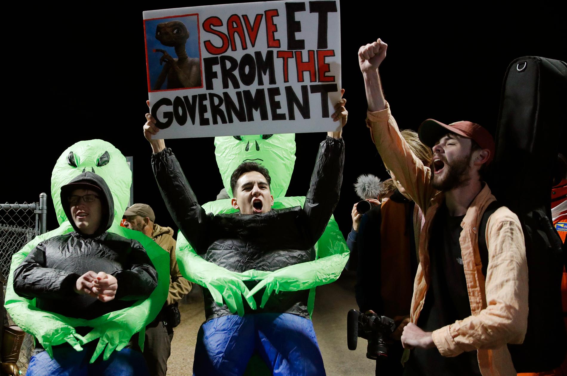 "Rädda ET från regeringen", har människor skrivit på plakat utanför Area 51.