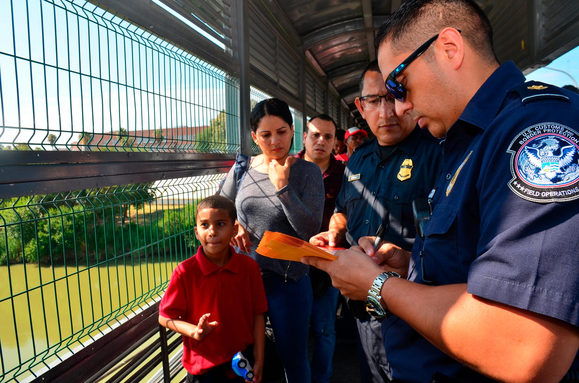 En amerikansk tulltjänsteman tar upp en asylansökan vid gränsen mellan Laredo, i delstaten Texas, och Mexiko. Arkivbild.