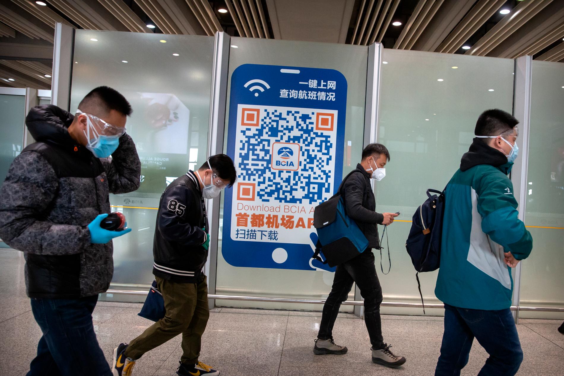 Resenärer med munskydd på flygplatsen i Peking. 