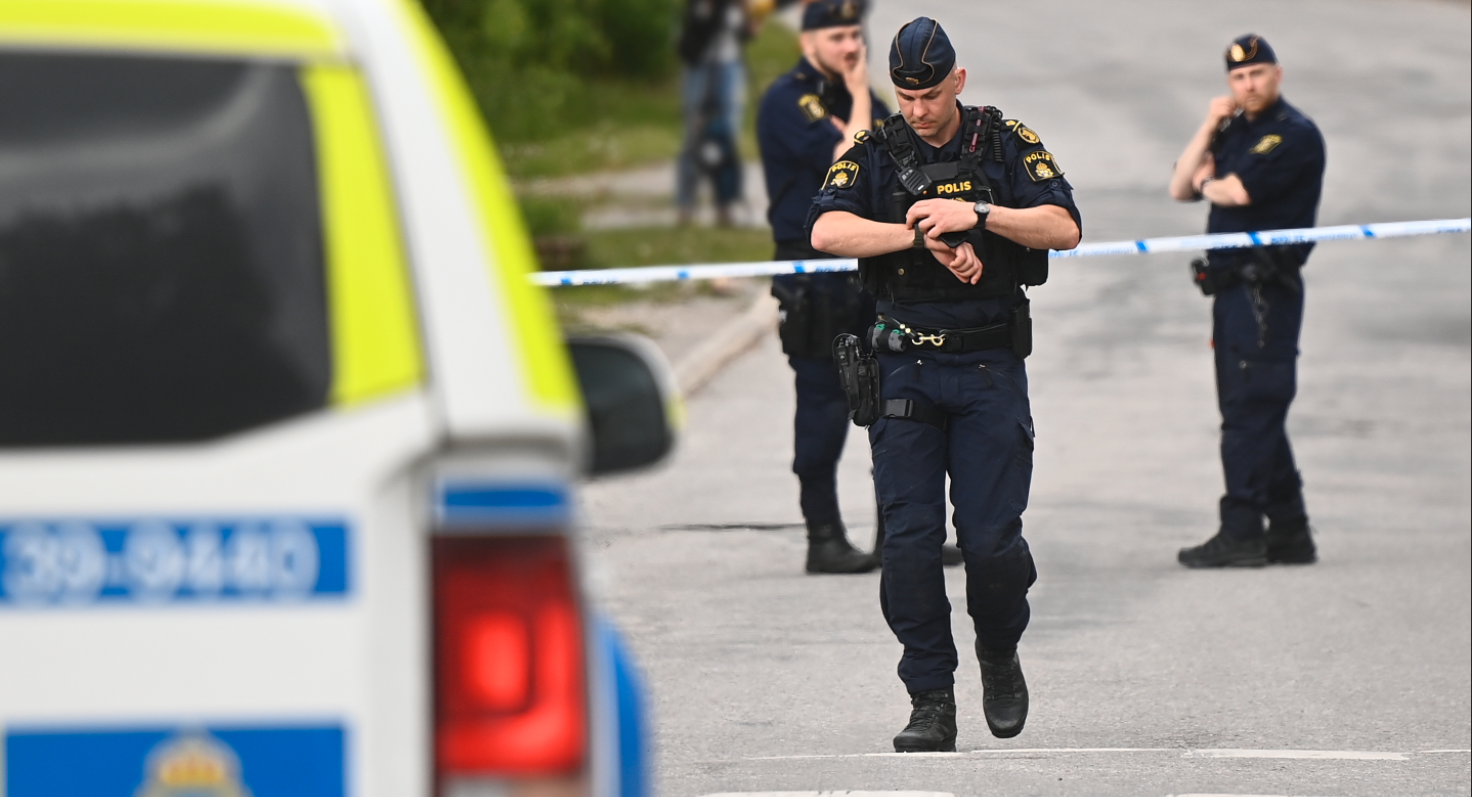 Poliser vid brottsplatsen i Mälarhöjden, Stockholm där en kvinna och ett barn höggs till döds. 