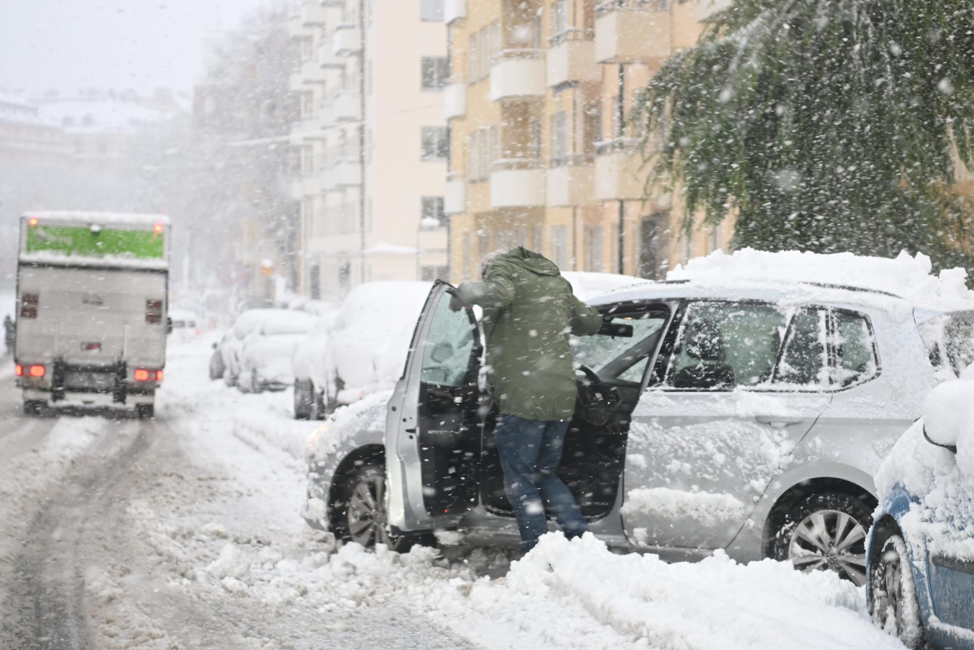 Bilist som skottar snö i Stockholm på måndagen. 