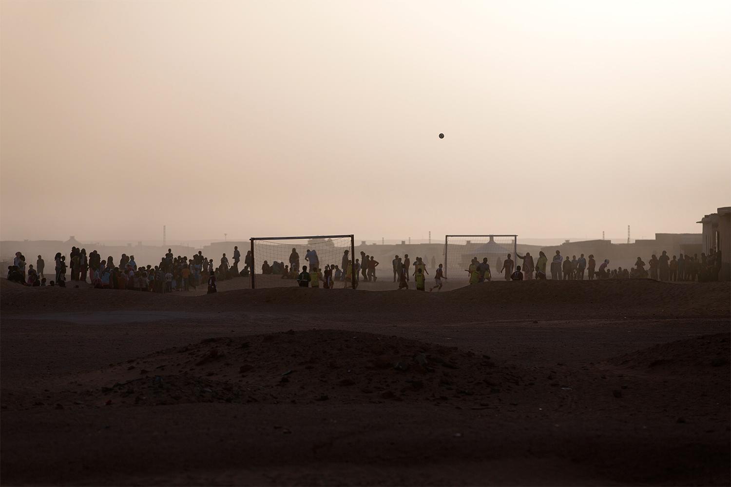 I skymningen pågår fotbollsmatcher i flyktinglägret Smara.Fotbollsturnering i flyktinglägret Smara. Västsahara har ett eget landslag, men får inte delta i VM eftersom landet inte är internationellt erkänt. Johan Persson
