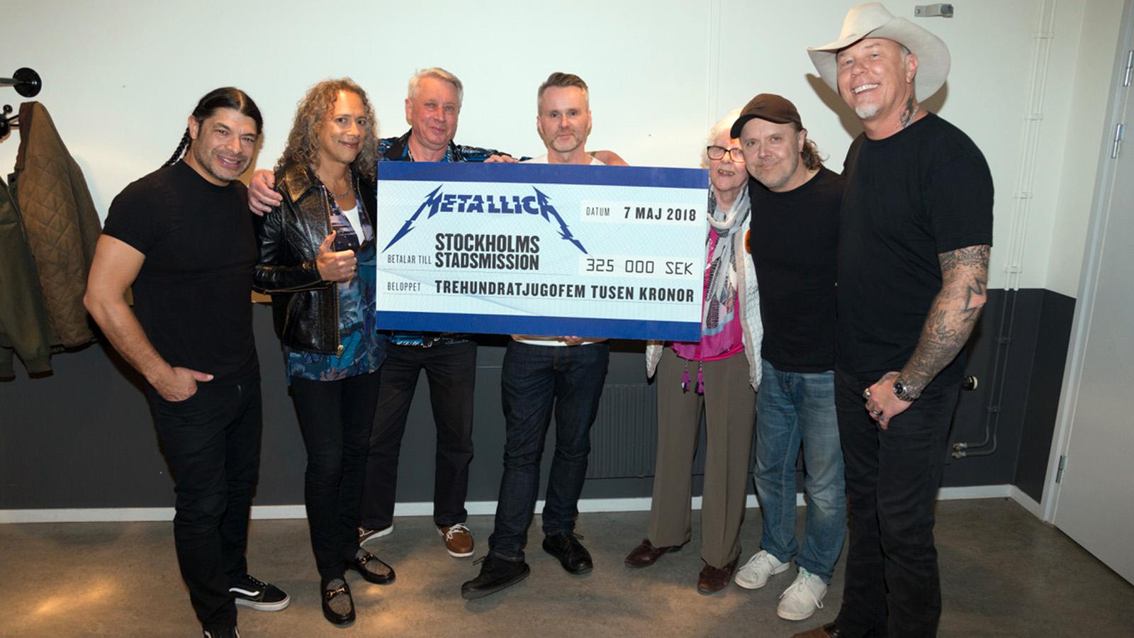 Metallica överräcker checken till Stockholms stadsmission.