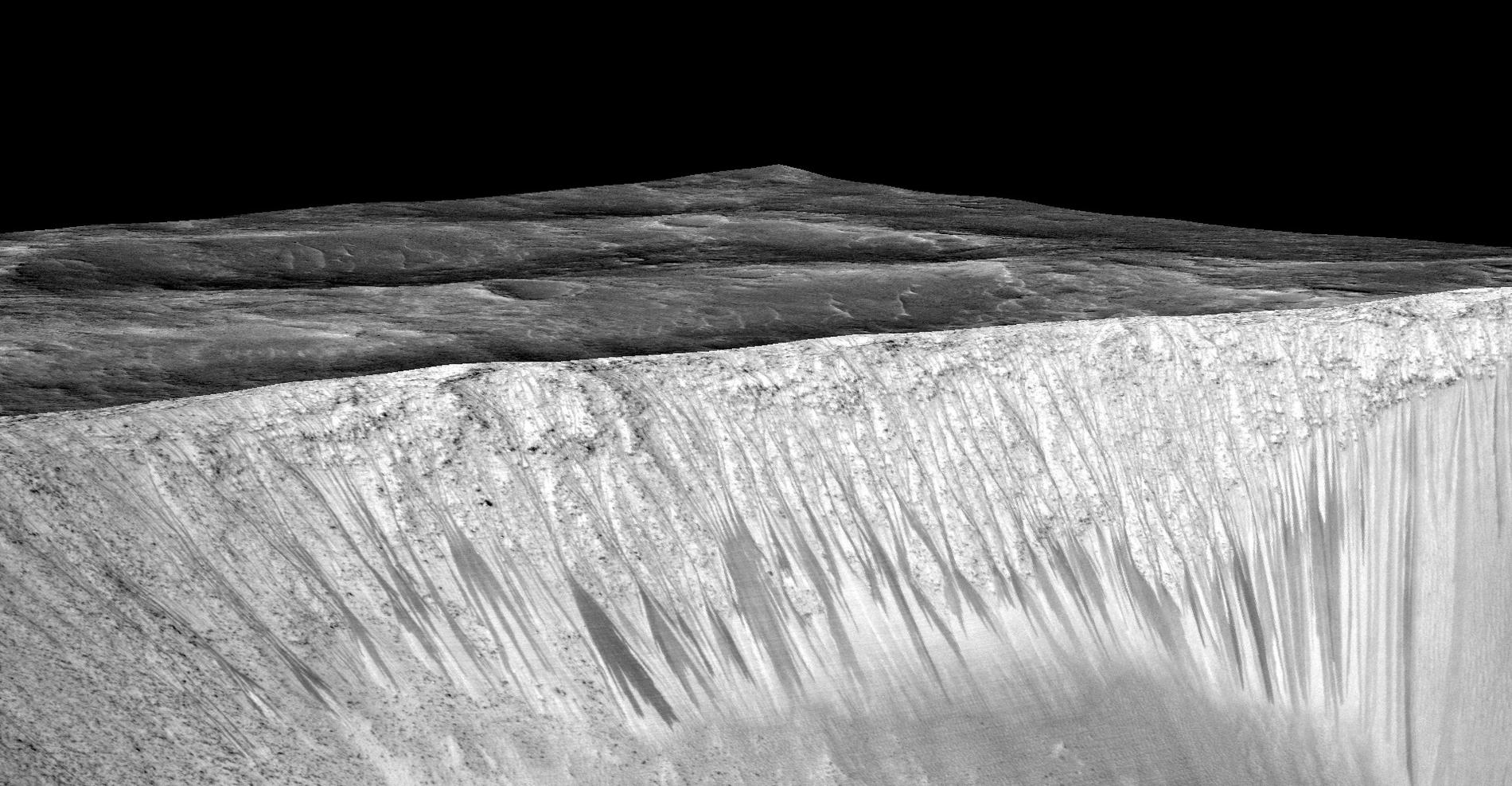 Mörka stråk längs sluttningen av kratern Garni på Mars. Stråken, som är några hundra meter långa, består av saltlösningar som bildas när vatten rann längs sluttningen.
