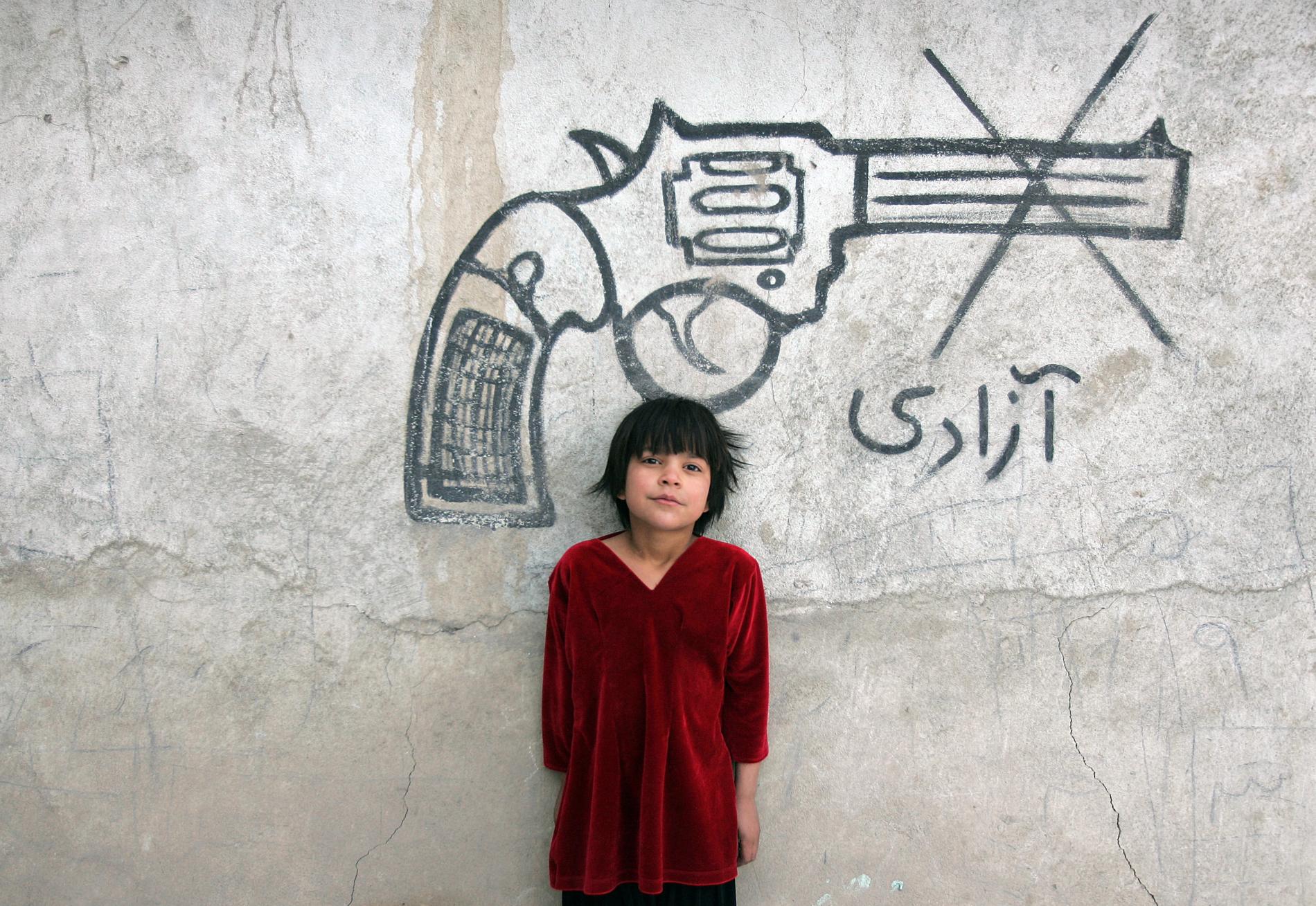Kan dagens avtal i Doha leda till fred i Afghanistan? På bilden ett barn i den afghanska huvudstaden Kabul framför en krigskritisk väggmålning. Arkivbild.