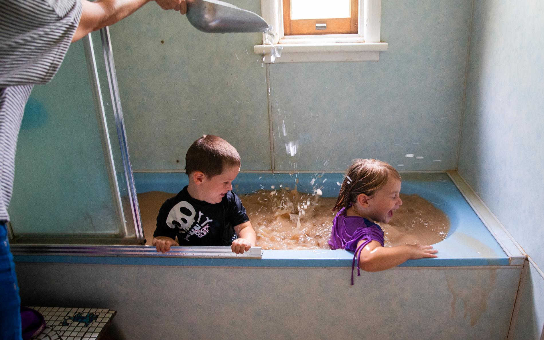 Talita Cohen och hennes bror Casey i Louth, Australien tar ett bad i det av torkan brunfärgade kranvattnet. Deras mor häller i is för ytterligare svalka.