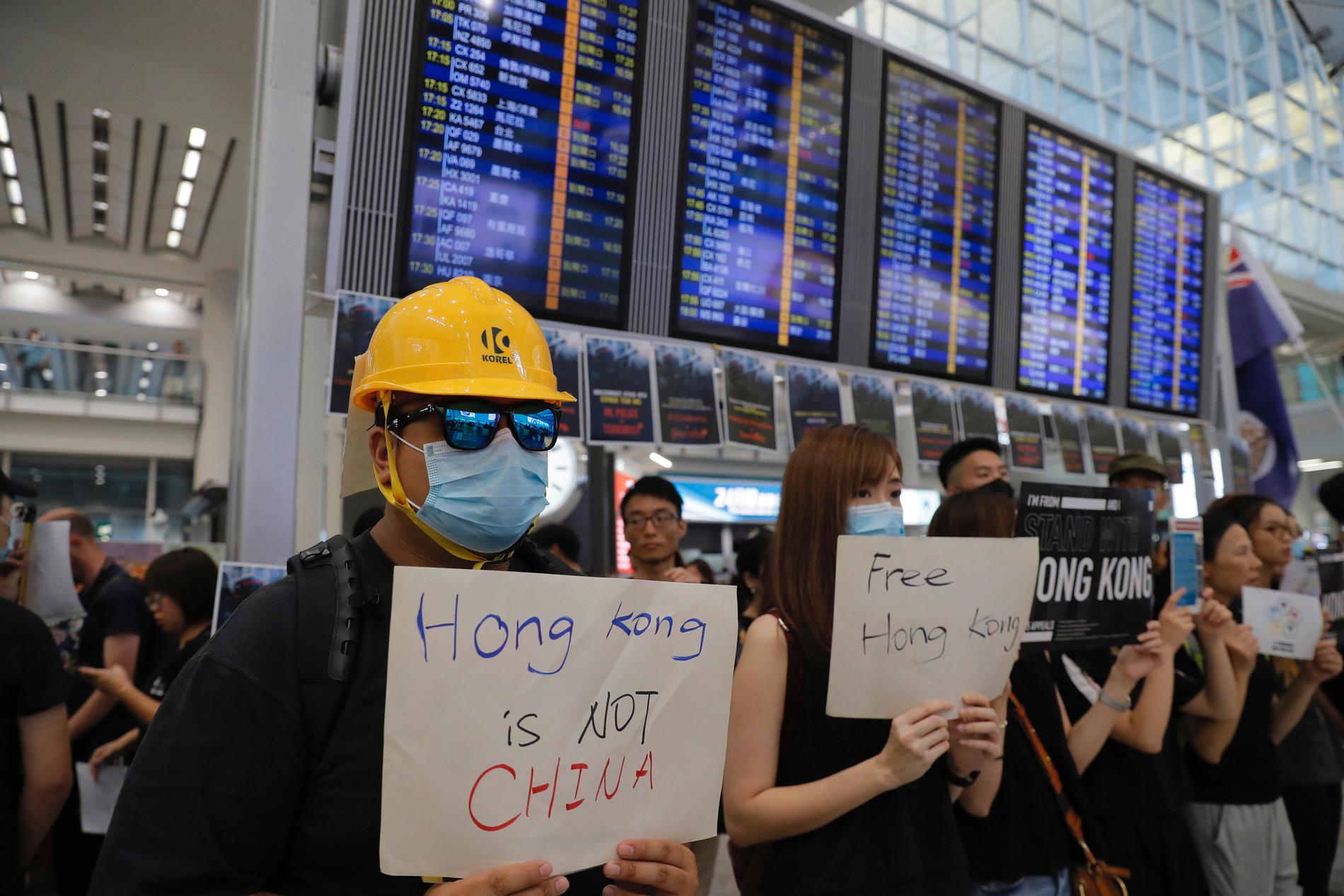 Demonstranter välkomnar människor som anländer till Hongkongs flygplats.