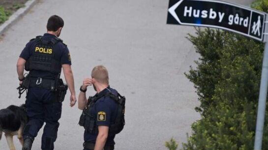 Poliser på plats i Husby efter mordet.