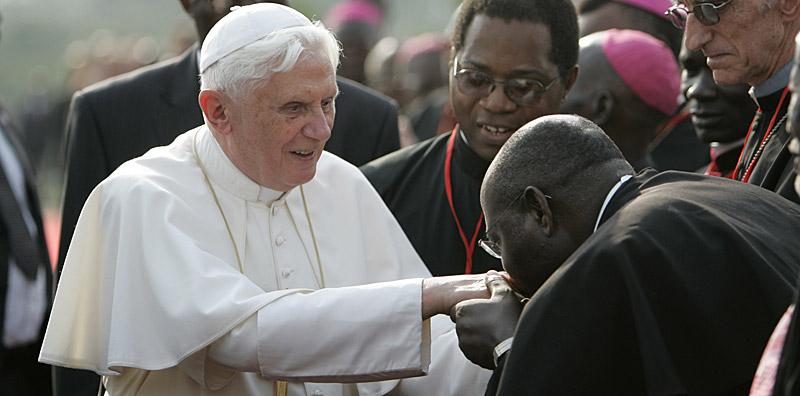 En pastor kysser påven Benedictus XVI:s ring när han anländer till flygplatsen i Yaounde i Kamerun.