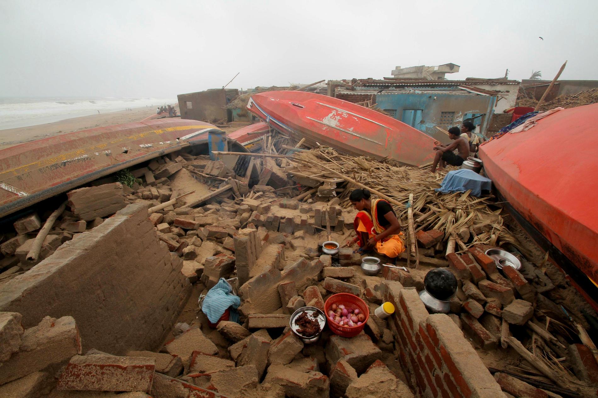 En kvinna lagar mat utomhus efter att hennes hus förstörts i cyklonen Fani. Arkivbild.