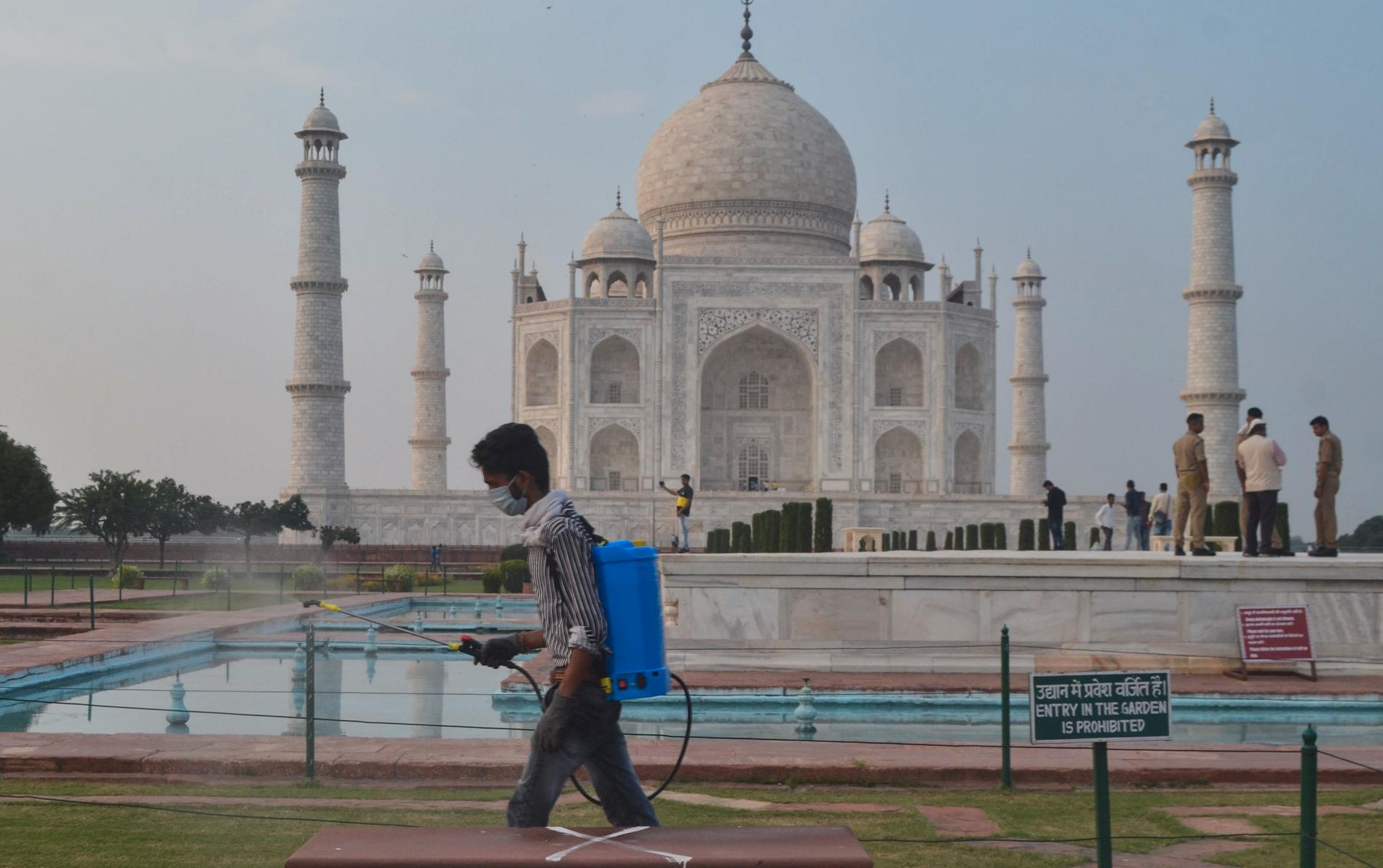 En man desinficerar området runt mausoleet Taj Mahal i Agra, Indien. Det världsarvslistade monumentet öppnade på onsdagen efter att ha varit stängt sedan april på grund av pandemin.