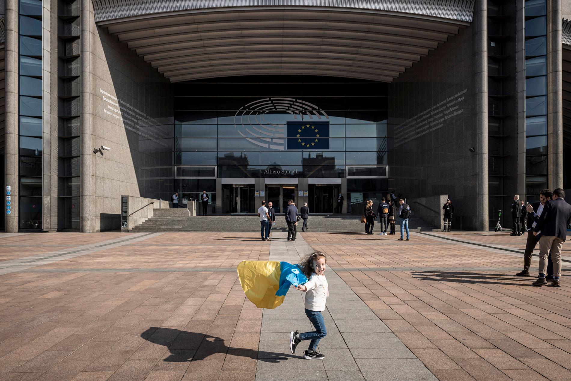 Glad flicka med ukrainsk flagga utanför EU-högkvarteret i Bryssel på torsdagen. 