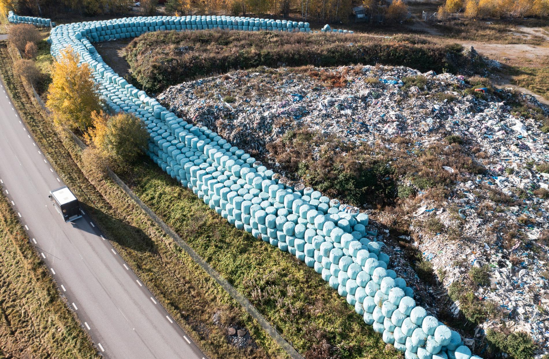 Nästan 40 000 ton osorterade sopor, delvis i ljusblå plastbalar, ligger utanför Skultuna i Västmanland. Nu åtalas personerna bakom företaget NMT Think Pink, som skulle ta hand om bland annat byggavfall. Arkivbild.