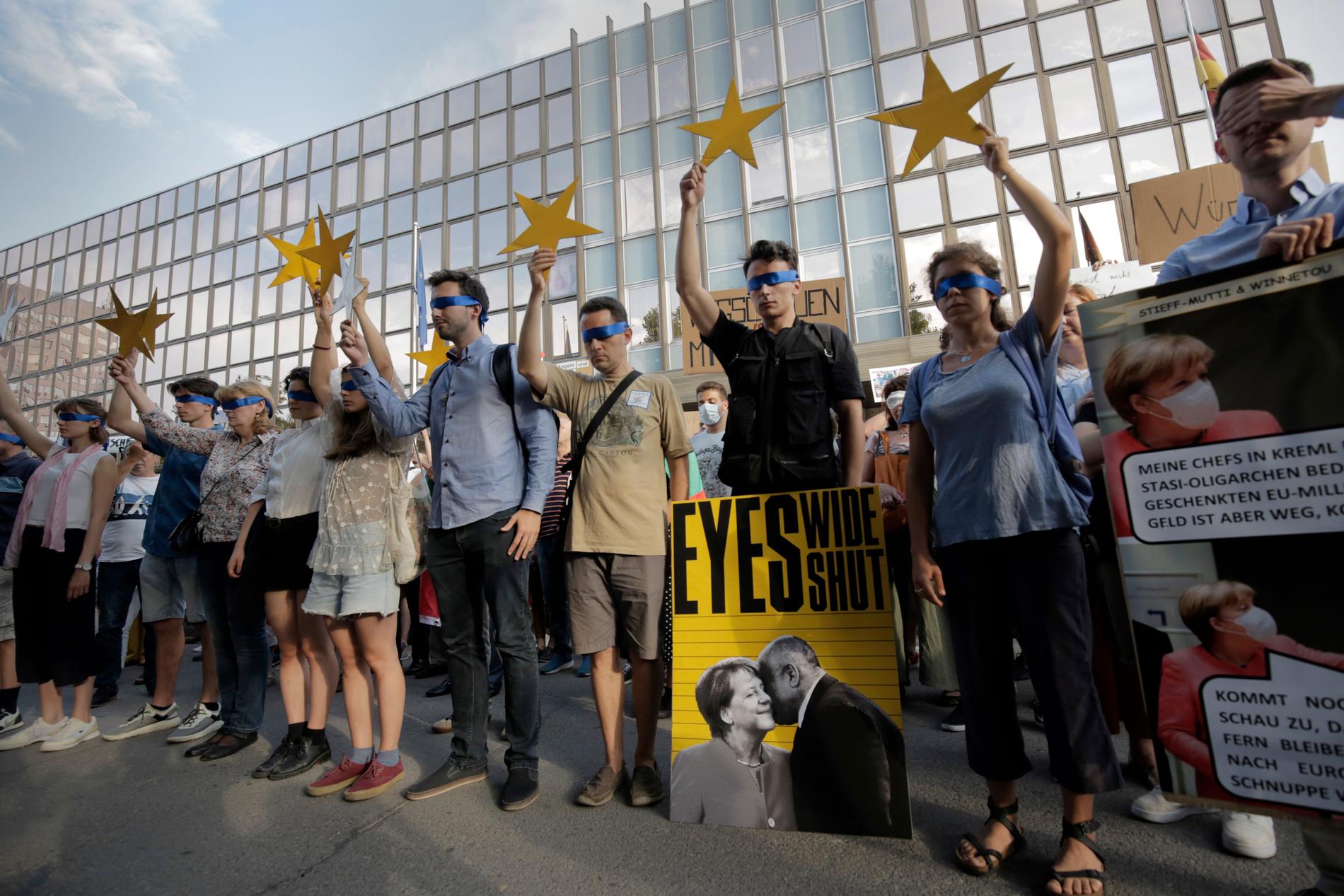 Demonstranter blundar och håller upp stjärnor som ska symbolisera EU:s medlemsstater i samband med en protest i mitten av augusti. Många av de som protesterar anser att EU har varit för tyst om den omfattande korruption i Bulgarien som de vill sätta ljuset på.