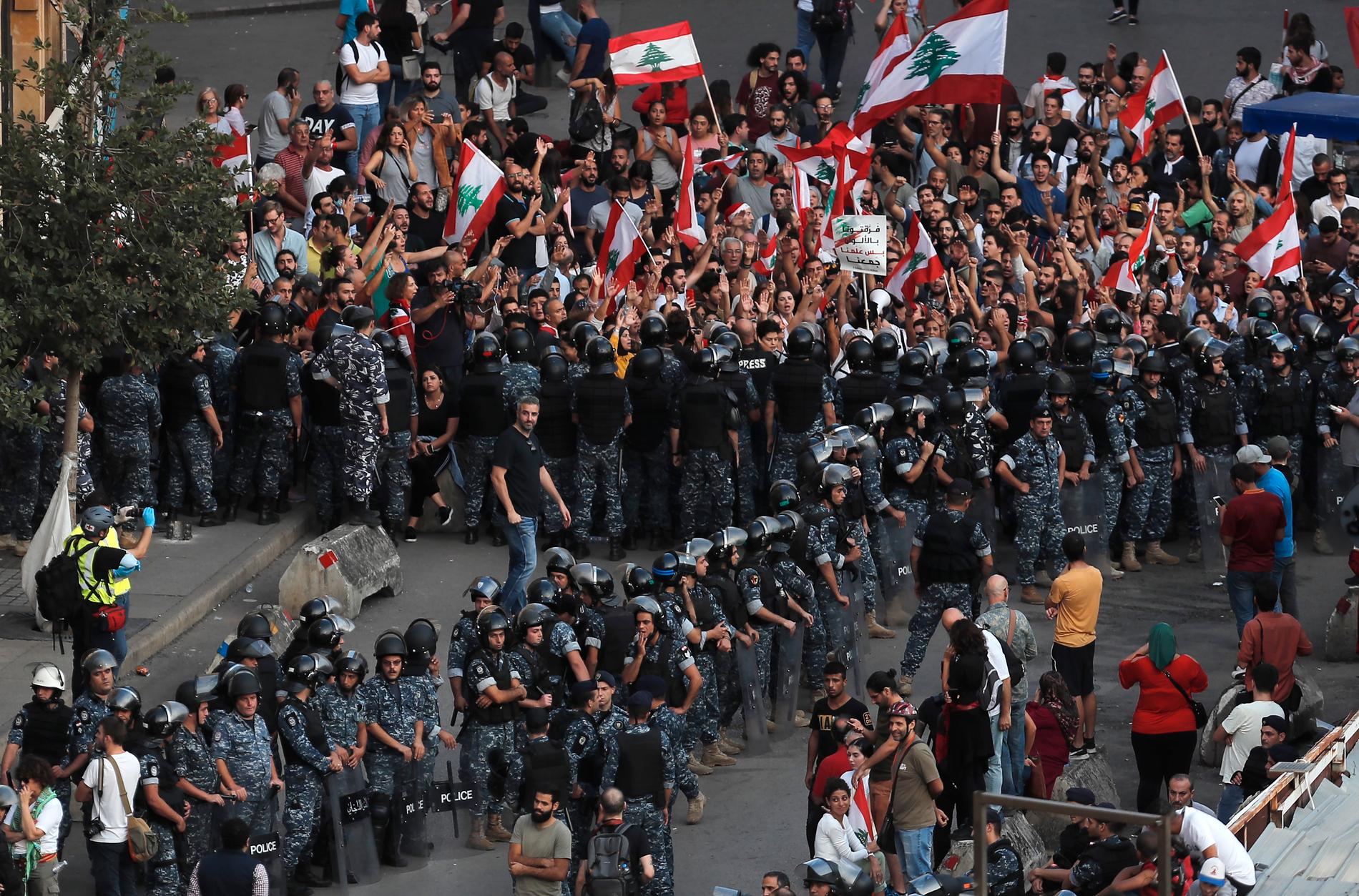 Libanesisk polis försöker att hålla isär demonstranter och motdemonstranter i Beirut den 25 oktober.