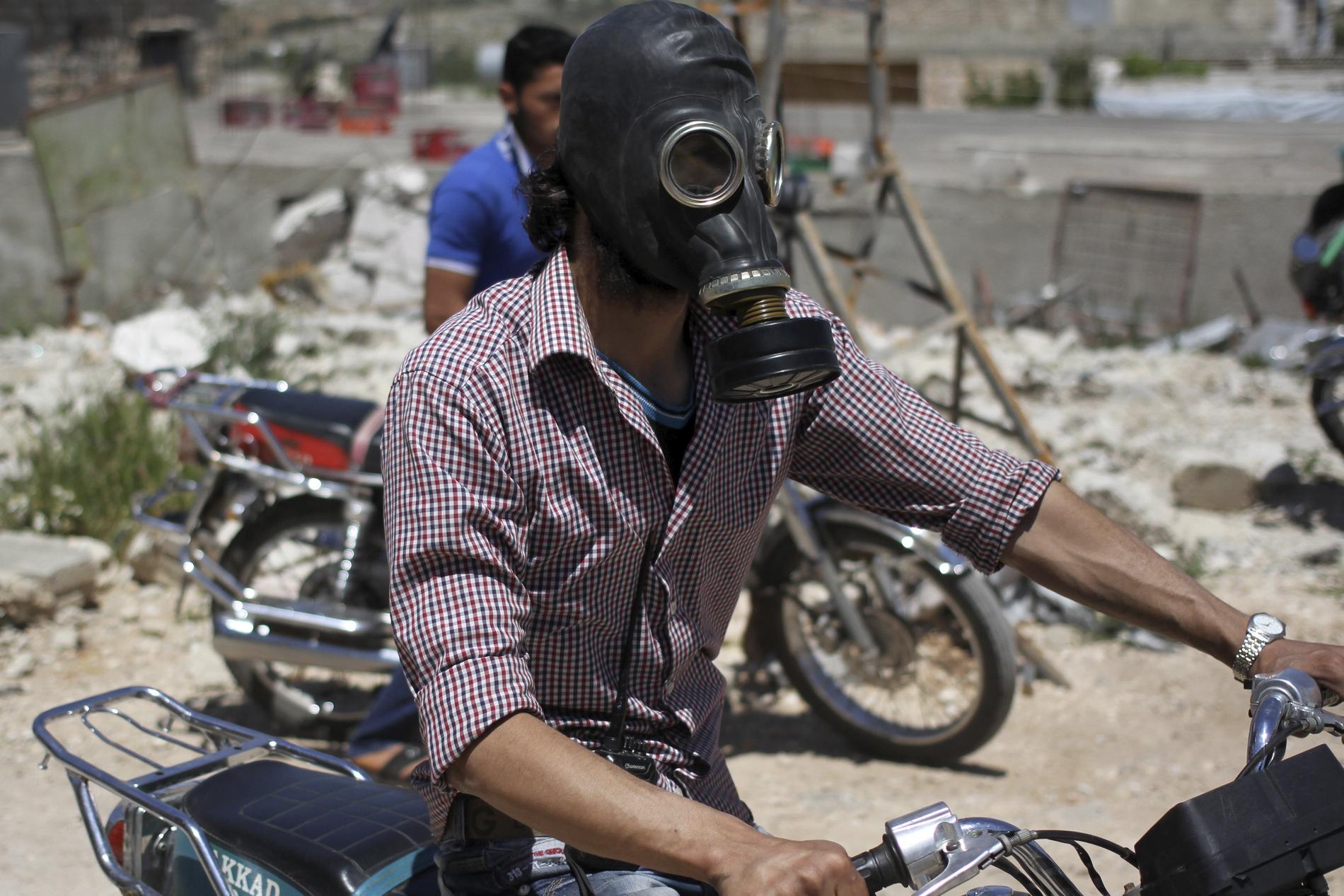 Civila bär gasmask i Kansafra. Rebeller hävdar att regeringssidan släppt klorgas i området.