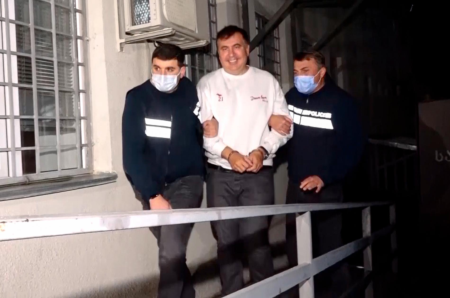 Georgiens expresident Mikhail Saakasjvili förs handfängslad mellan två poliser in i ett fängelse i staden Rustavi, söder om den georgiska huvudstaden Tbilsi. Fotot har distribuerats av det georgiska inrikesdepartementet.