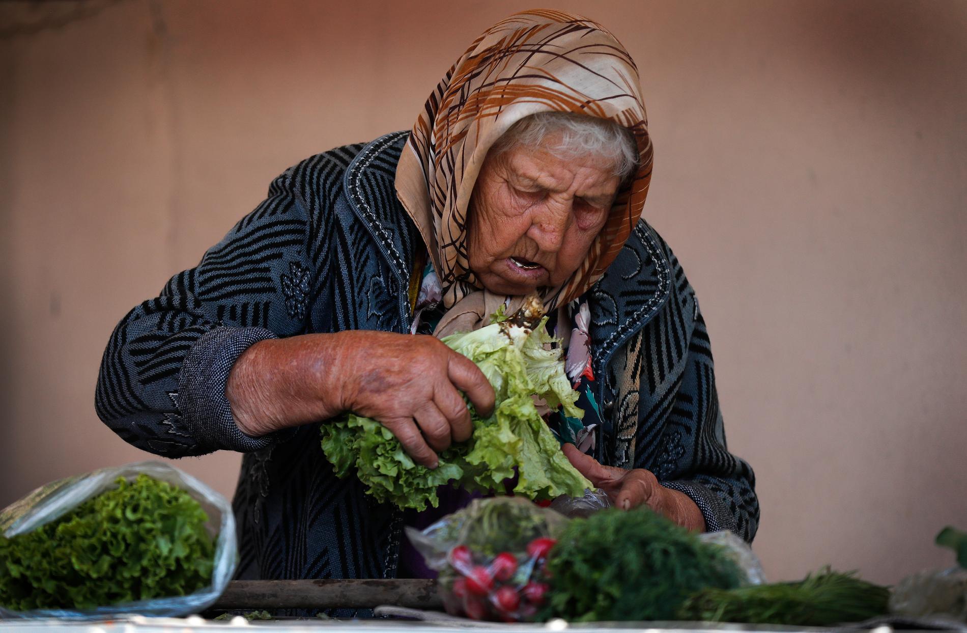 En rysk kvinna säljer grönsaker på en marknad under sommarens fotbolls-VM. 