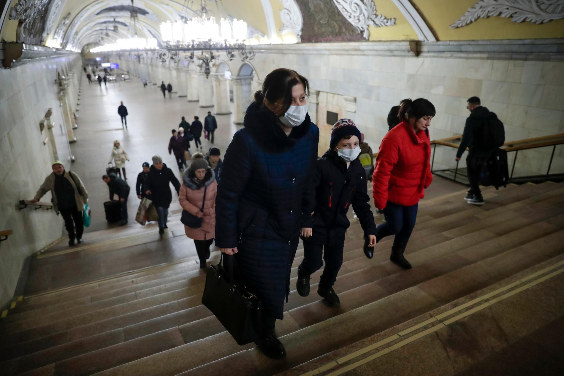 En kvinna och ett barn iförda munskydd på Komsomolskaja-stationen i Moskvas tunnelbana, i onsdags.