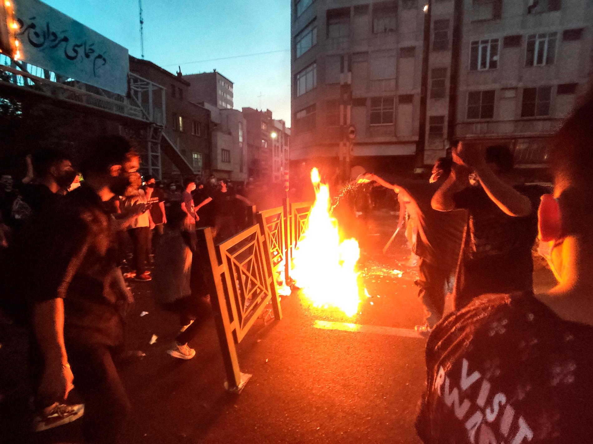 Demonstranter eldar och blockerar gatan under en protest efter Mahsa Aminis död.