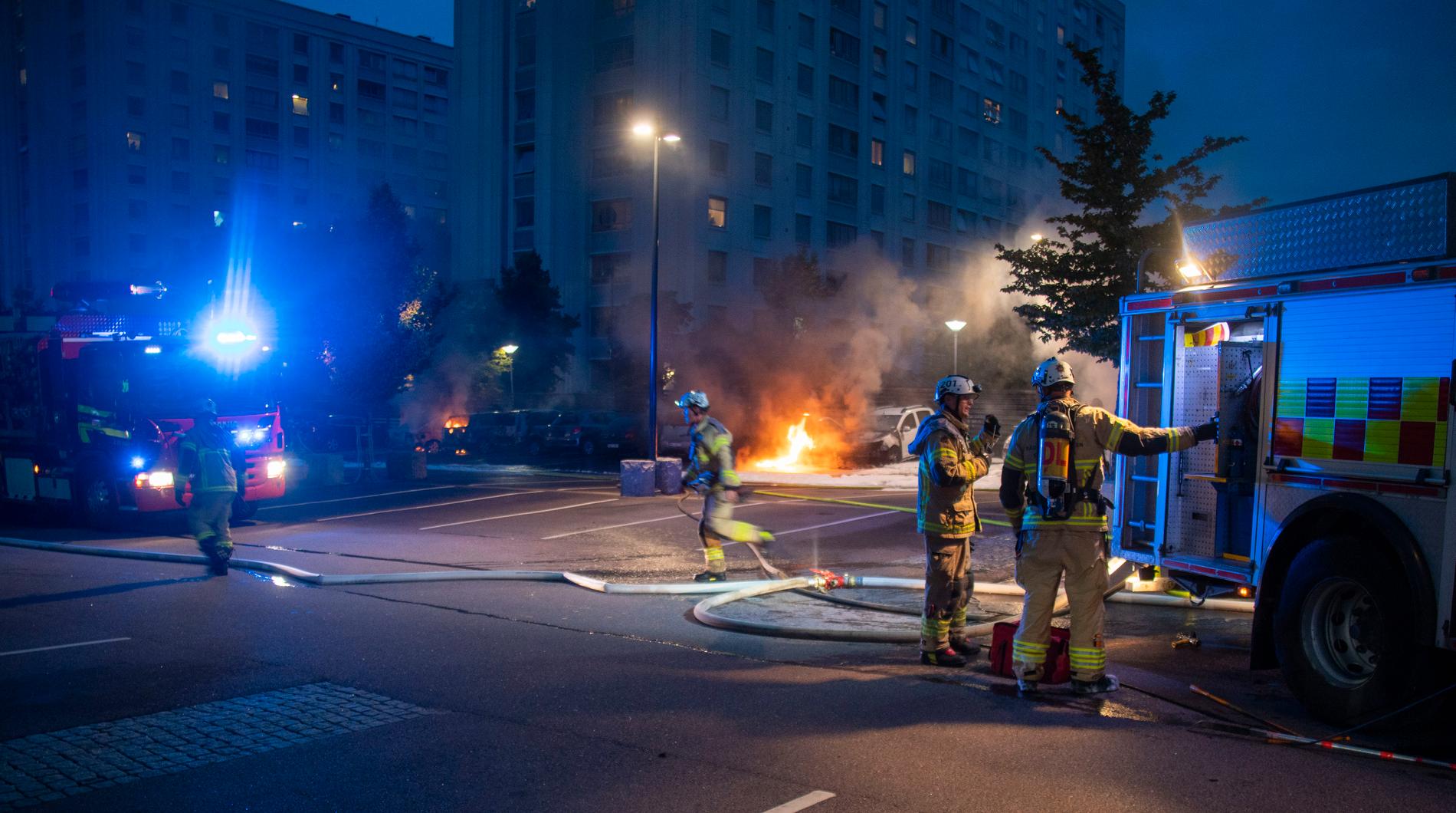 Brandmän släcker de många bilbränderna vid Frölunda torg.