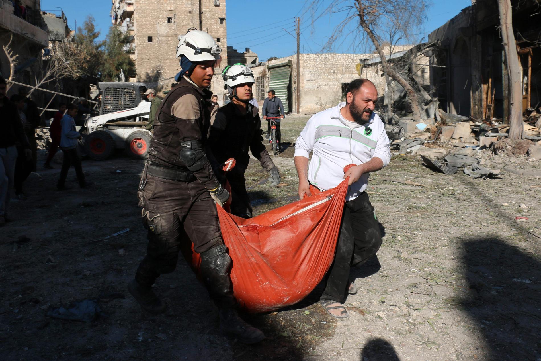 Räddningsarbetare från Vita hjälmarna tar hand om offer för bombräder i stadsdelen Bob al-Nayrab, östra Aleppo.