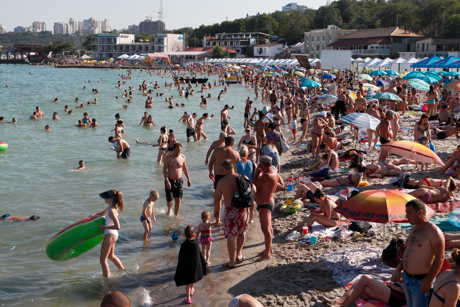 Semesterfirare på stranden i Odessa i juli 2020. Svarta havets vackra stränder brukar vanligtvis locka tiotusentals besökare under sommaren. Nu grävs de om till skyttegravar. 